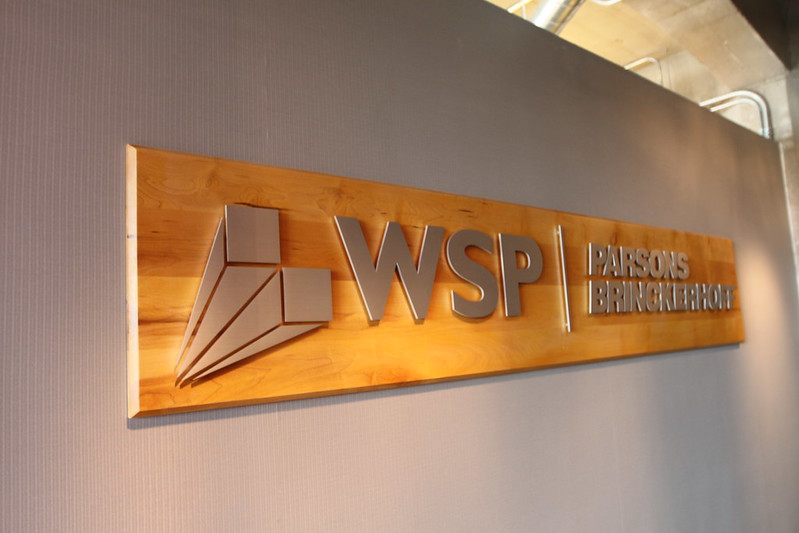 Wooden backer panel for metal logo