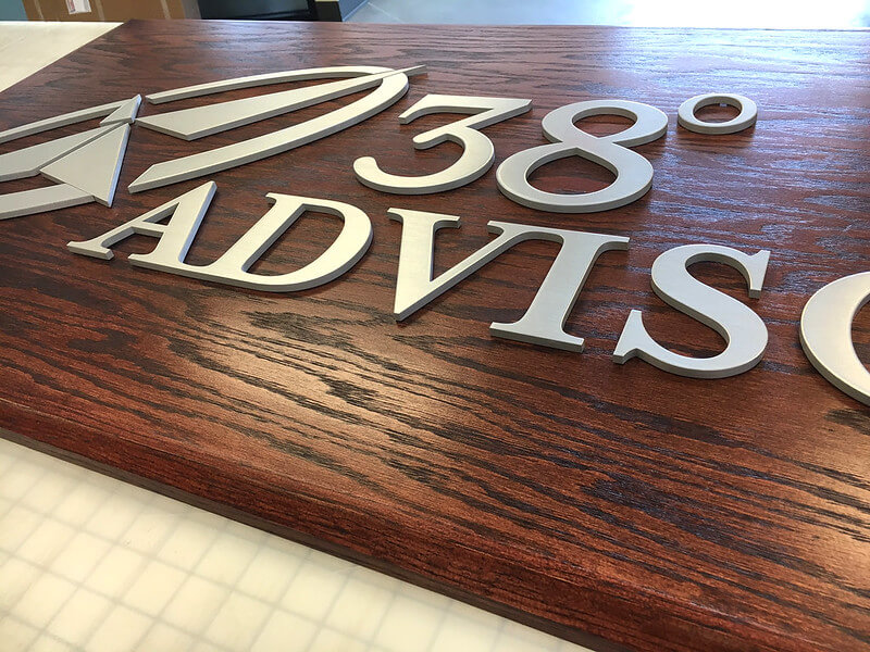 Wooden panel with raised metal logo