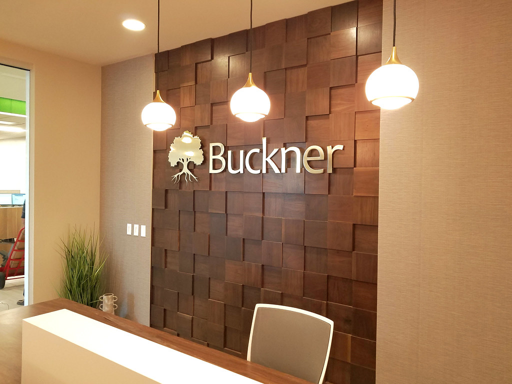 48" wide 1/4" thick Brushed Brass logo and lettering for interior insurance company lobby sign Installed on custom layered wall panels