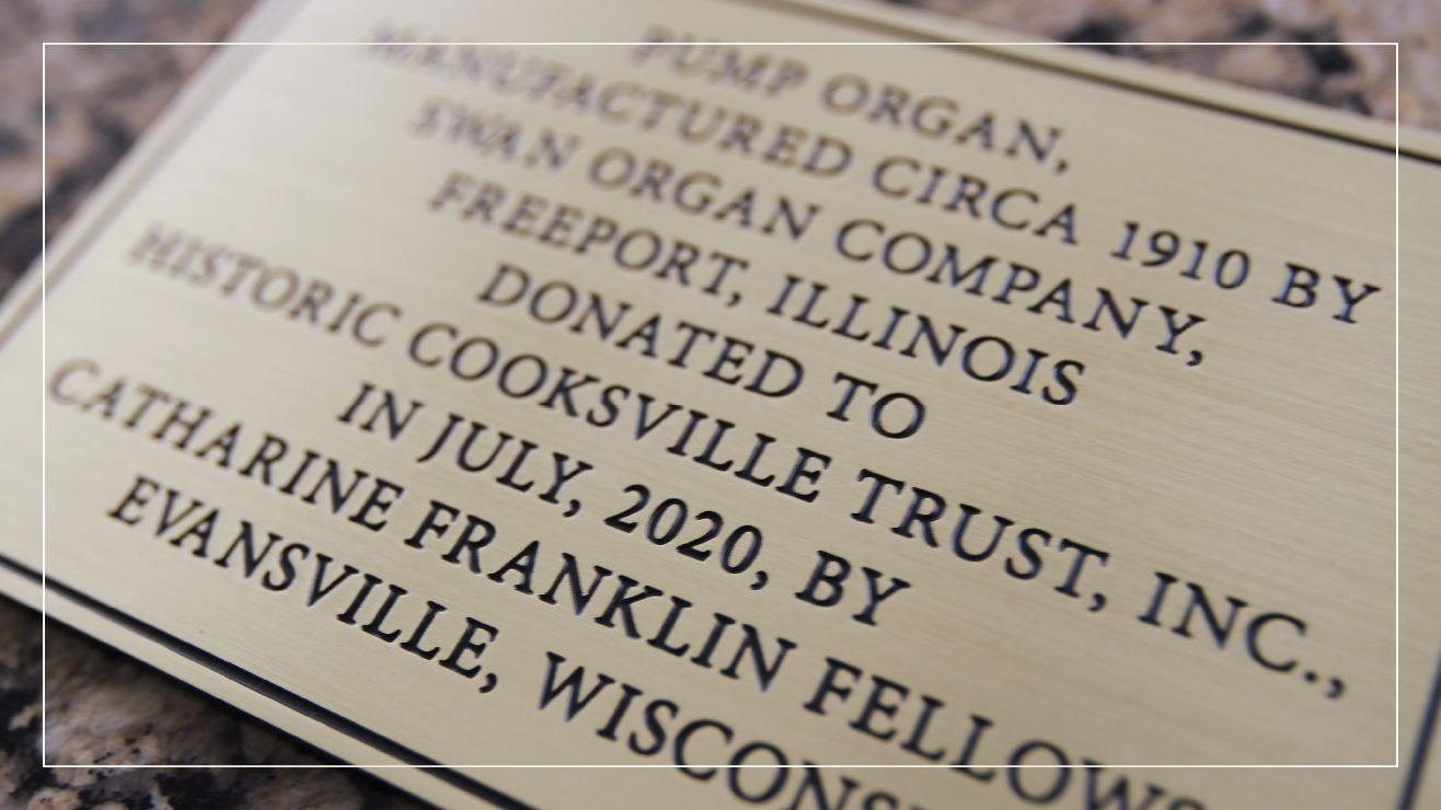 A brass plaque commemorating the manufacturing of a pump organ in 1910.