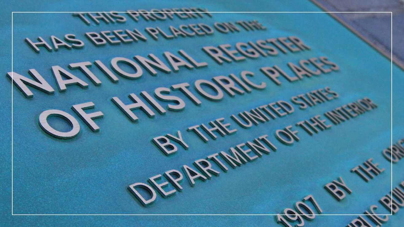 A bronze plaque with a natural patina.