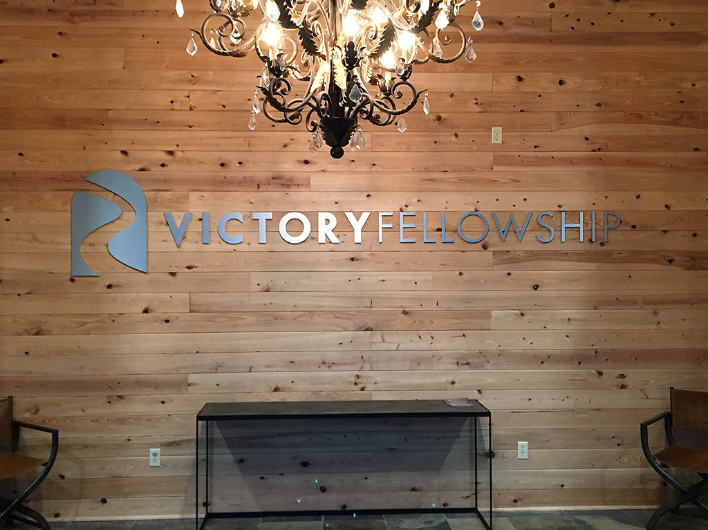 Brushed Aluminum Logo on Wooden Panel Wall