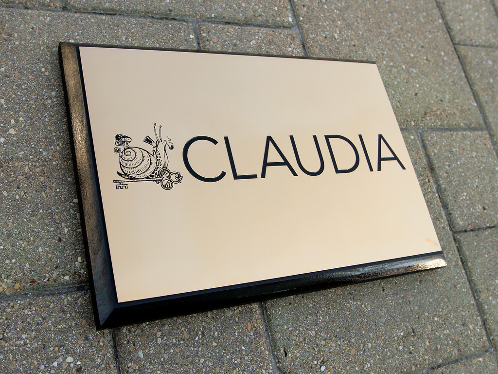 Etched bronze logo plaque on wooden panel backer