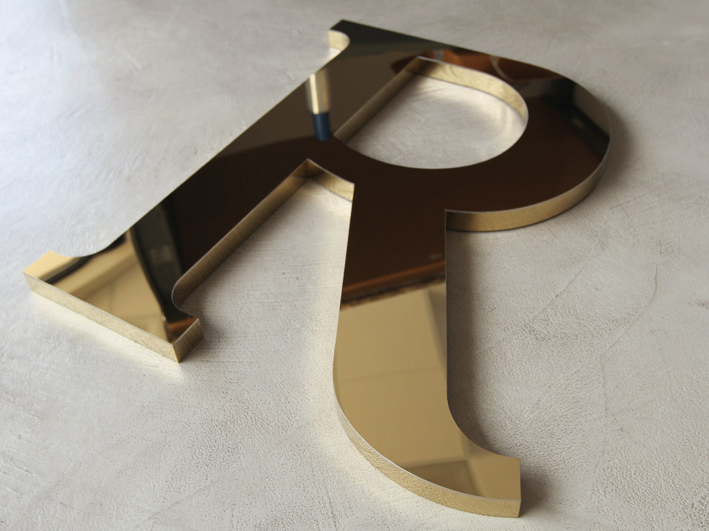 Polished gold titanium fabricated letter