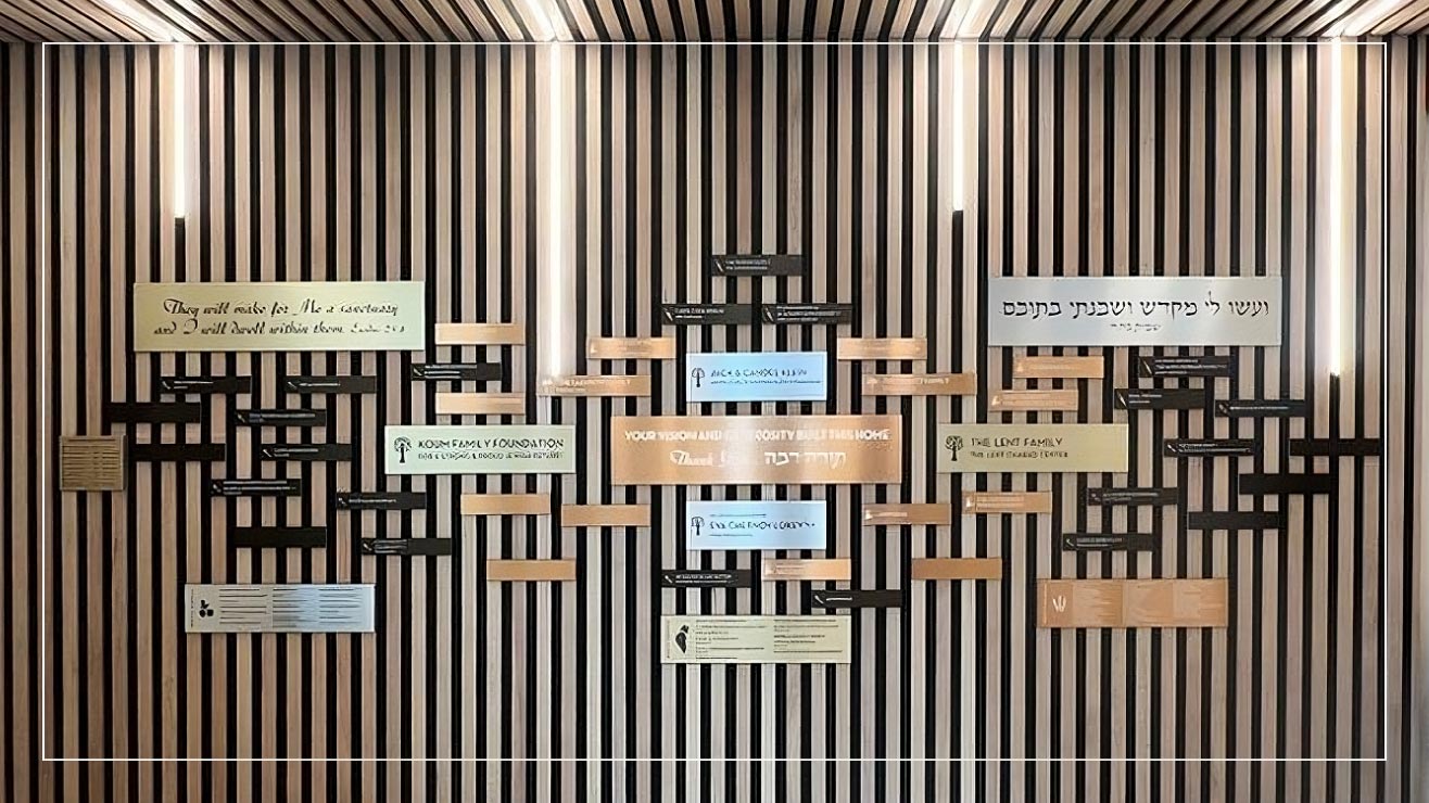 A sponsor wall features plaques of various sizes and metals with inscriptions for sponsors.