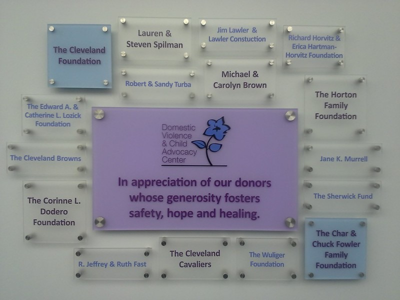 A collection of paint-injected glass signage honoring donors to the Domestic Violence & Child Advocacy Center.