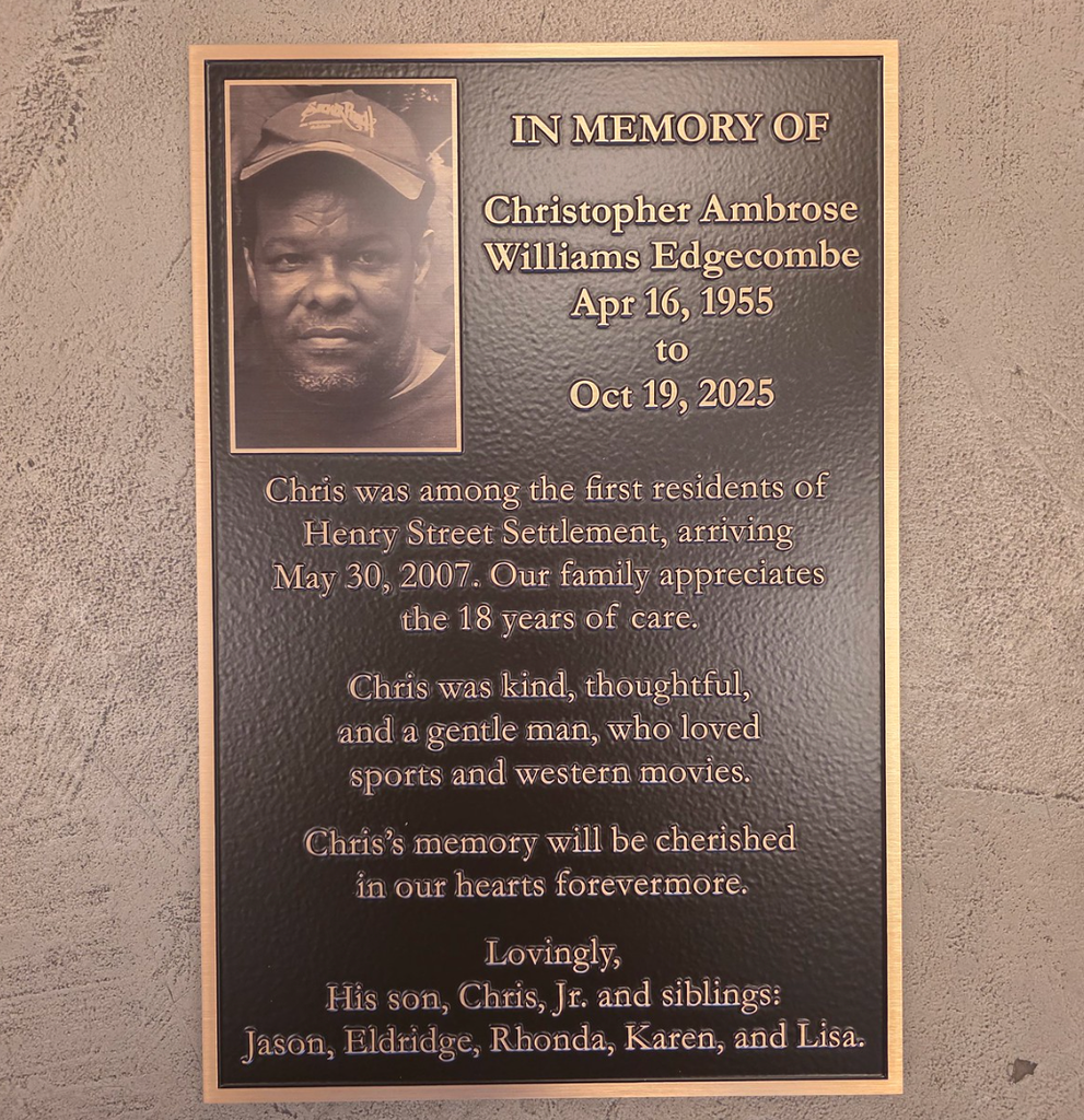 A cast bronze memorial plaque including an image.